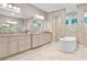 Well-lit primary bathroom featuring dual vanities, a soaking tub, and walk-in shower at 4224 Clarice Estates Dr, Windermere, FL 34786