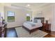 Beautiful bedroom with lake views featuring tray ceiling, hardwood floors, and modern décor at 4224 Clarice Estates Dr, Windermere, FL 34786