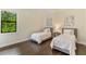 Comfortable bedroom featuring twin beds, hardwood flooring, and bright natural light at 4224 Clarice Estates Dr, Windermere, FL 34786