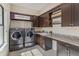 Spacious laundry room with dark cabinetry, granite counters, and modern washer and dryer at 4224 Clarice Estates Dr, Windermere, FL 34786