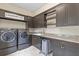 A spacious laundry room features modern appliances, custom cabinetry, and granite countertops at 4224 Clarice Estates Dr, Windermere, FL 34786