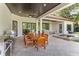 Covered outdoor dining area with wood table and chairs, barbecue, and jacuzzi at 4224 Clarice Estates Dr, Windermere, FL 34786