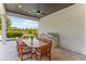 Covered patio with dining area, outdoor kitchen, and views of lake and landscaped yard at 4224 Clarice Estates Dr, Windermere, FL 34786