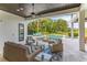 Beautiful covered patio with cozy seating overlooking a private pool and lush backyard at 4224 Clarice Estates Dr, Windermere, FL 34786