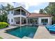 A stunning backyard featuring a pool, jacuzzi, covered patio, and outdoor kitchen at 4224 Clarice Estates Dr, Windermere, FL 34786