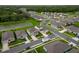 An aerial view of a suburban neighborhood with houses, ponds, and a tree-lined perimeter at 4338 Finch Ln, Kissimmee, FL 34746