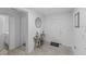 Bright entryway featuring tiled flooring, neutral walls, decorative table with round mirror and a white front door at 4338 Finch Ln, Kissimmee, FL 34746