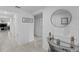Bright hallway featuring tiled flooring, neutral walls, decorative table with round mirror leading to the living areas at 4338 Finch Ln, Kissimmee, FL 34746