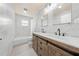 Modern bathroom features double sinks, decorative mirrors, and a tub with marble-look tile at 4607 Pine Lake Dr, St Cloud, FL 34769