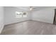 Bright bedroom featuring wood-look floors and natural light from a large window at 4607 Pine Lake Dr, St Cloud, FL 34769
