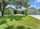 Charming single-story home with a well-manicured lawn, mature trees, and an attached two-car garage at 4607 Pine Lake Dr, St Cloud, FL 34769