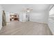 Open-concept living space with wood-look floors and ceiling fan; kitchen in background at 4607 Pine Lake Dr, St Cloud, FL 34769