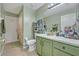 Bathroom with a vanity and sink, a toilet, a shower over tub, and light-green painted walls at 6396 Bennett Ct, St Cloud, FL 34771