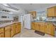 Spacious kitchen featuring wood cabinets, a large refrigerator, and a view of the dining area at 6396 Bennett Ct, St Cloud, FL 34771