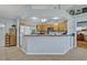 Bright kitchen featuring wooden cabinets, tiled floors, and a breakfast bar overlooking the rest of the house at 6396 Bennett Ct, St Cloud, FL 34771