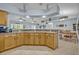 Open kitchen with breakfast bar, wood cabinets, and views of the dining area and living room at 6396 Bennett Ct, St Cloud, FL 34771
