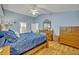Cozy main bedroom with blue walls, vaulted ceilings, and wood floors at 6396 Bennett Ct, St Cloud, FL 34771