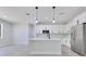 Contemporary kitchen with white cabinetry, stainless steel appliances, and a center island with pendant lights at 7 Spring Pass, Ocala, FL 34472