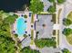 Aerial view of pool with lounge seating, umbrellas, and a clubhouse next to parking at 8897 Rhodes St, Kissimmee, FL 34747