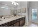 Spacious primary bathroom featuring dual sinks, granite countertops, and walk in shower at 8897 Rhodes St, Kissimmee, FL 34747