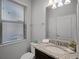 Well-lit half bathroom with a granite countertop, modern fixtures, and a window at 8897 Rhodes St, Kissimmee, FL 34747