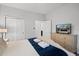 Bright bedroom with a TV, closet, and a comfortable bed with decorative pillows and bedding at 8897 Rhodes St, Kissimmee, FL 34747