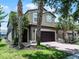 Charming two-story home with tropical landscaping, brick driveway, a two-car garage and an arched entry at 8897 Rhodes St, Kissimmee, FL 34747