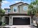 Charming two-story home featuring a tile roof and a two-car garage with tropical landscaping at 8897 Rhodes St, Kissimmee, FL 34747