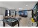 Spacious game room with a large screen projector, foosball table, and cozy seating area at 8897 Rhodes St, Kissimmee, FL 34747