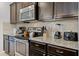 Well-equipped kitchen features stainless steel appliances, granite countertops, and dark wood cabinetry at 8897 Rhodes St, Kissimmee, FL 34747
