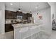 Modern kitchen featuring dark cabinets, granite countertops, stainless steel appliances, and a spacious island with seating at 8897 Rhodes St, Kissimmee, FL 34747