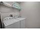 Functional laundry room with a washer, dryer, and shelving for efficient organization at 8897 Rhodes St, Kissimmee, FL 34747