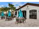 Outdoor seating at the Tu Casa bar and lounge with palm trees and blue umbrellas at 8897 Rhodes St, Kissimmee, FL 34747