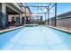 Screened-in pool showcases crystal blue water, adjacent spa, and an outdoor living space perfect for relaxation at 8897 Rhodes St, Kissimmee, FL 34747