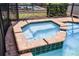 Close up of a heated spa with brick detailing, sitting adjacent to the sparkling blue pool at 8897 Rhodes St, Kissimmee, FL 34747