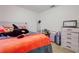 Bedroom features an orange fuzzy blanket and light colored dresser at 10 Pine Track Trl, Ocala, FL 34472