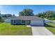 Charming single-story home with well-manicured lawn, attached garage, and neutral gray paint at 10 Pine Track Trl, Ocala, FL 34472
