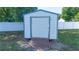 Metal storage shed with wooden access ramp on a grassy lot at 10 Pine Track Trl, Ocala, FL 34472