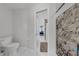 Modern bathroom with a marble-tiled walk-in shower and view into the main bedroom at 1063 Fountainhead Dr, Deltona, FL 32725