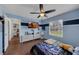 This cozy bedroom features hardwood floors, a ceiling fan, and a TV for entertainment, plus a peek into an adjacent room at 1063 Fountainhead Dr, Deltona, FL 32725