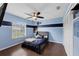 This blue and white bedroom features hardwood floors, a ceiling fan, and a large window for plenty of natural light at 1063 Fountainhead Dr, Deltona, FL 32725