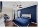 This bedroom features a modern ceiling fan, hardwood floors, and a stylish blue accent wall and sleek white headboard at 1063 Fountainhead Dr, Deltona, FL 32725