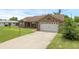 Charming single-story brick home featuring a two-car garage, well-manicured lawn, and inviting curb appeal at 1063 Fountainhead Dr, Deltona, FL 32725