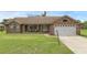 Inviting single-story brick home with a well-kept front lawn, a two-car garage, and an open front porch area at 1063 Fountainhead Dr, Deltona, FL 32725