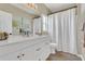 Bathroom featuring white vanity with dual sinks, and shower with white curtain at 1118 Saint Tropez Ct, Kissimmee, FL 34759