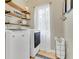 Laundry room with washer, dryer, shelving, baskets, and tile floor at 1118 Saint Tropez Ct, Kissimmee, FL 34759