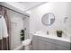 Bright bathroom featuring a modern vanity with round mirror and a tiled shower with stylish accents at 12104 Shallot St, Orlando, FL 32837