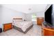Bedroom featuring tile floors, natural light, and wooden furniture, creating a warm, inviting space at 12104 Shallot St, Orlando, FL 32837