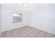 This bedroom offers neutral paint, tile flooring, and a bright window at 12104 Shallot St, Orlando, FL 32837
