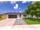 Charming single-story home featuring a gray-tone front door, gray-tone garage, solar panels, and well-maintained landscaping at 12104 Shallot St, Orlando, FL 32837